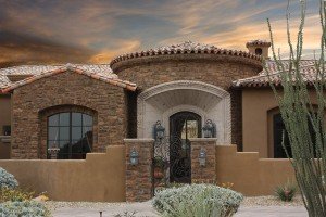 A beautiful home exterior featuring a Cobblestone (Cobble stone) style stone veneer and a restucco with a smooth stucco finish